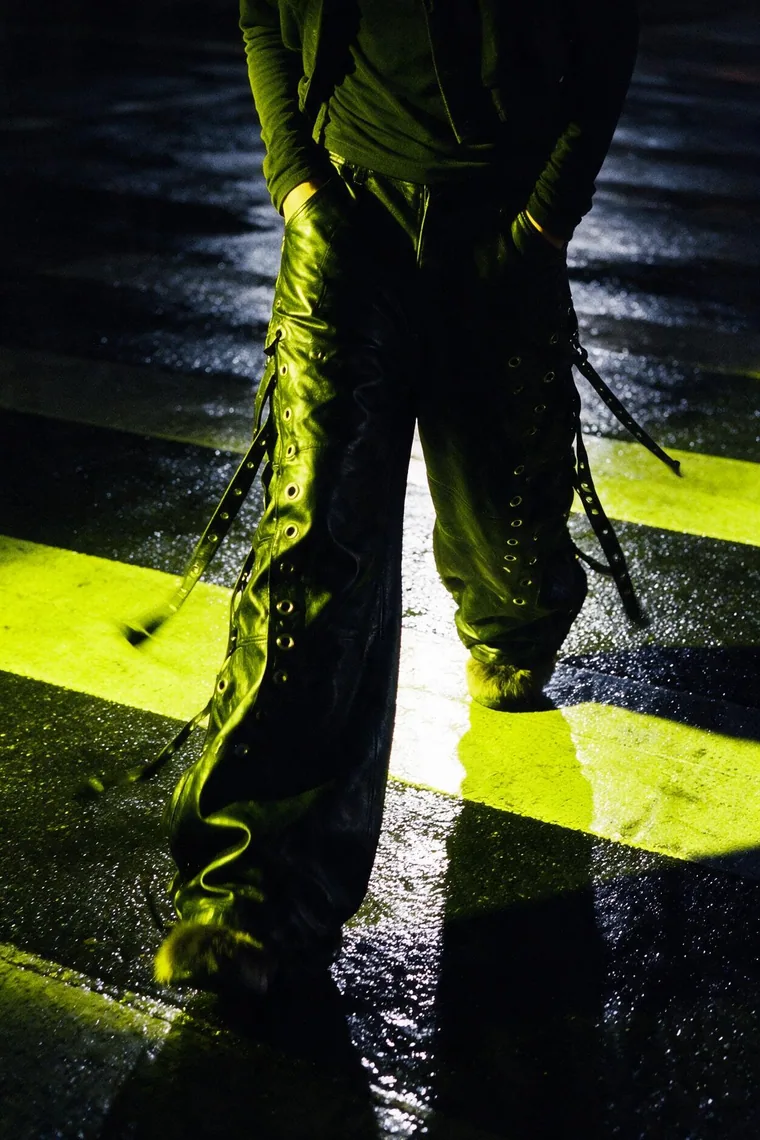Boots on a wet road, lit by one beam